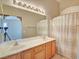 Bathroom featuring double sinks, with an arched window over a tub/shower, a large mirror, and lights at 9005 Meisenheimer Ave, Las Vegas, NV 89143