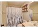 Cozy bathroom features decorative floating shelves, a sink, a toilet, and a shower/tub combo at 9005 Meisenheimer Ave, Las Vegas, NV 89143