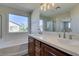 Bright bathroom with a large window, double vanity, and a soaking tub at 9102 Brilliant Prairie Ct, Las Vegas, NV 89149