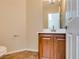 Half bathroom featuring a dark wood vanity, tile floors, white walls, and a decorative mirror at 9102 Brilliant Prairie Ct, Las Vegas, NV 89149