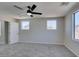 Neutral bedroom with plush carpet, ceiling fan, and two windows at 9102 Brilliant Prairie Ct, Las Vegas, NV 89149