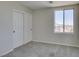 Cozy bedroom with plush carpeting, a double door closet, and a large window with neighborhood views at 9102 Brilliant Prairie Ct, Las Vegas, NV 89149