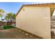 Beige stucco exterior wall and terra cotta roof of a home with gravel landscaping and green lawn at 9102 Brilliant Prairie Ct, Las Vegas, NV 89149