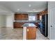 Spacious kitchen with wooden cabinets, a tile backsplash, and a granite countertop island at 9102 Brilliant Prairie Ct, Las Vegas, NV 89149