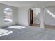 Airy living room with fresh carpet, arched window and stylish stairway at 9102 Brilliant Prairie Ct, Las Vegas, NV 89149