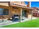 Covered backyard patio with black wicker furniture and outdoor area with synthetic lawn at 951 Carnival Ave, Las Vegas, NV 89123