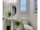 Cozy bathroom with pedestal sink, white toilet, and bright natural light from window at 712 N Water St, Henderson, NV 89015