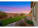 Green backyard with manicured landscaping, a brick patio, and block wall at 10184 Fire Skye Ave, Las Vegas, NV 89166