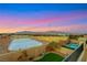 Expansive backyard with a pool, sports court, and mountain views at sunset at 10184 Fire Skye Ave, Las Vegas, NV 89166