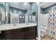 Bathroom featuring a double sink vanity, modern fixtures, large mirrors, and a shower/tub combo at 10184 Fire Skye Ave, Las Vegas, NV 89166