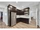 Well-equipped kitchen with stainless steel refrigerator, microwave, and dark wood cabinets at 10184 Fire Skye Ave, Las Vegas, NV 89166