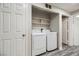 Laundry area with a modern washer and dryer, shelving, and dual door access at 1050 E Cactus Ave # 1049, Las Vegas, NV 89183