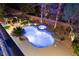 Aerial view of a luxurious pool and spa surrounded by lush landscaping and an outdoor living space at 10644 San Vercelli Ct, Las Vegas, NV 89141