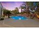 Backyard oasis with a swimming pool, desert landscaping and outdoor lighting at 10644 San Vercelli Ct, Las Vegas, NV 89141