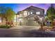 Exterior front elevation of the house at dusk with a three-car garage and landscaped yard at 10644 San Vercelli Ct, Las Vegas, NV 89141