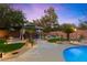 Backyard featuring manicured desert landscaping, a gazebo, and pool with concrete walkway at 10644 San Vercelli Ct, Las Vegas, NV 89141