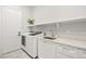 Bright laundry room features modern appliances, white cabinetry, and ample counter space at 10644 San Vercelli Ct, Las Vegas, NV 89141