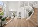 Stunning living room featuring tall ceilings, natural light, and elegant wood staircase at 10644 San Vercelli Ct, Las Vegas, NV 89141