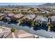 An aerial view of a neighborhood featuring well-maintained homes with desert landscaping and a backdrop of scenic mountains at 12279 Lost Treasure Ave, Las Vegas, NV 89138