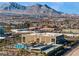 Aerial view of a city featuring commercial buildings, houses, and mountains in the background at 12279 Lost Treasure Ave, Las Vegas, NV 89138