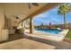 Outdoor entertaining area featuring covered patio, pool, spa, and tropical landscaping at 12279 Lost Treasure Ave, Las Vegas, NV 89138