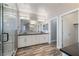 Bathroom with double vanity, walk-in shower, wood-look flooring, and modern lighting at 12279 Lost Treasure Ave, Las Vegas, NV 89138