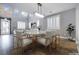 Open dining area with modern chandelier, stone accent wall and large windows at 12279 Lost Treasure Ave, Las Vegas, NV 89138