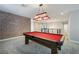 Spacious upstairs game room showcases a classic billiards table, brick wall, and custom light at 12279 Lost Treasure Ave, Las Vegas, NV 89138