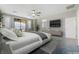 Staged bedroom with a TV, access to the ensuite bathroom, and a sliding door to the balcony at 12279 Lost Treasure Ave, Las Vegas, NV 89138