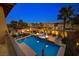 Backyard view of a pool, hot tub, fire pits, and desert landscape at twilight at 12279 Lost Treasure Ave, Las Vegas, NV 89138