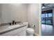 Contemporary powder room with sleek fixtures, quartz countertop, and sliding door access to outdoor pool area at 12279 Lost Treasure Ave, Las Vegas, NV 89138