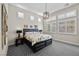 Bright bedroom with plantation shutters, modern light fixture and a large comfortable bed with patterned carpet at 12374 Skyracer Dr, Las Vegas, NV 89138