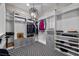 Spacious walk-in closet featuring built-in shelving, drawers, hanging rods and modern light fixture with patterned carpet at 12374 Skyracer Dr, Las Vegas, NV 89138