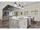 Modern kitchen with a marble island, stainless steel appliances, and open to the living room at 12374 Skyracer Dr, Las Vegas, NV 89138