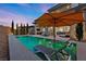 Stunning pool area with submerged lounge chairs and an umbrella, perfect for relaxing in the sun at 12374 Skyracer Dr, Las Vegas, NV 89138