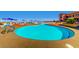 Resort-style swimming pool with ample seating and blue umbrellas for shade on a sunny day at 1395 Kapelle St, Henderson, NV 89052