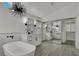 Modern bathroom with a standalone tub, dual vanities, mirrored closet, and unique light fixture at 2008 Arbor Forest St, Las Vegas, NV 89134