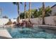 Inviting swimming pool with a natural rock waterfall, surrounded by mature palm trees and desert landscaping at 2008 Arbor Forest St, Las Vegas, NV 89134