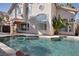 Backyard pool with a tanning ledge, rock waterfall feature, and views of the home's architecture at 2008 Arbor Forest St, Las Vegas, NV 89134