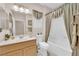 Bright bathroom showcases a shower-tub combo, framed mirror, and neutral tile flooring at 2244 Garden City Ave, Henderson, NV 89052