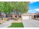 Inviting front exterior with decorative gate, lush landscaping, and a spacious driveway leading to a two-car garage at 2244 Garden City Ave, Henderson, NV 89052