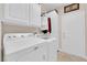 Functional laundry room featuring a white washer and dryer set and overhead cabinets at 2244 Garden City Ave, Henderson, NV 89052