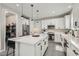 Bright kitchen boasts white cabinets, a center island, stainless appliances, and modern pendant lighting at 225 Sul Ponticello Ave, Las Vegas, NV 89011