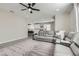 Bright living room with a grey sectional couch and tile floors that flow to an adjacent kitchen at 225 Sul Ponticello Ave, Las Vegas, NV 89011