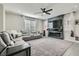 Open-concept living room with a large sectional, modern fireplace, and lots of natural light at 225 Sul Ponticello Ave, Las Vegas, NV 89011