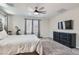 Bedroom featuring a large window, dresser, ceiling fan, carpeted floors, and comfortable furnishings at 225 Sul Ponticello Ave, Las Vegas, NV 89011