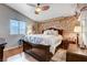 Comfortable bedroom with a brick accent wall, a ceiling fan, and natural light, creating a cozy atmosphere at 2345 Steinke Ln, Las Vegas, NV 89108