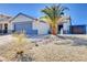 Single-story home with desert landscaping, concrete driveway, and a gray two car garage at 2345 Steinke Ln, Las Vegas, NV 89108