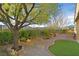 Landscaped backyard featuring decorative rocks, trees, and a walkway at 2405 Gamma Ray Pl, Henderson, NV 89044