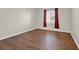 Bedroom with wood-look floors and window with decorative curtains at 2405 Gamma Ray Pl, Henderson, NV 89044